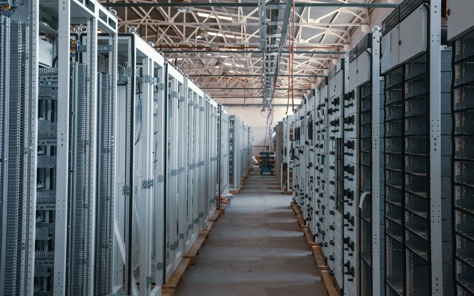 Long aisle of metal equipment racks in a data centre hall