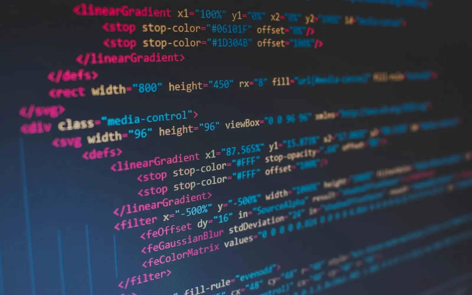 Close-up of HTML and SVG source code on a dark monitor